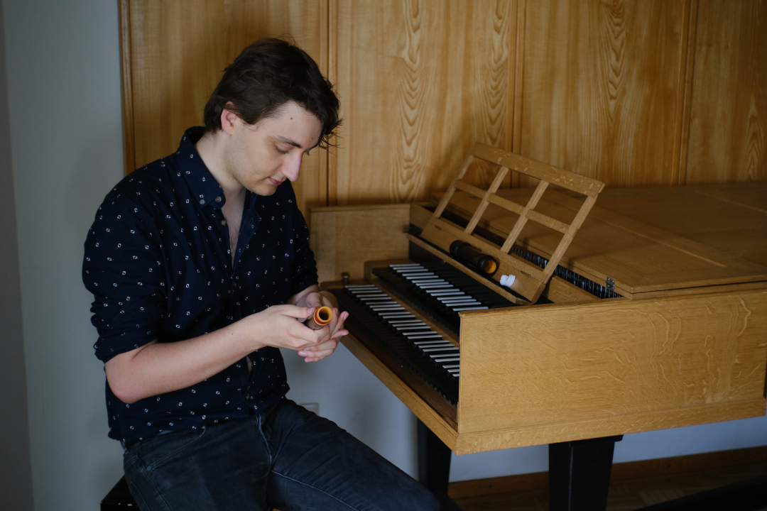 Laurens Paulsen sitting at a harpsichord with a recorder in his hands